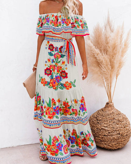 Full-length view of a women's off-shoulder floral maxi dress in white with colorful embroidery and a red waist tie.