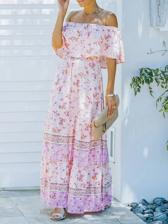 Light pink floral off-shoulder ruffled maxi dress with tiered skirt and delicate flower patterns, holding a clutch.