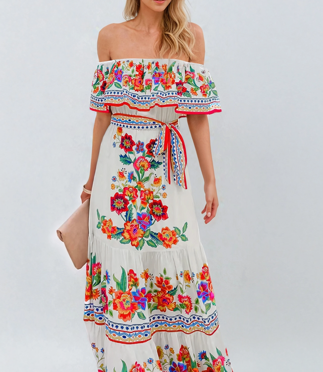 Women's off-shoulder ruffled maxi dress in white with vibrant red, orange, and blue floral print, tied at the waist.