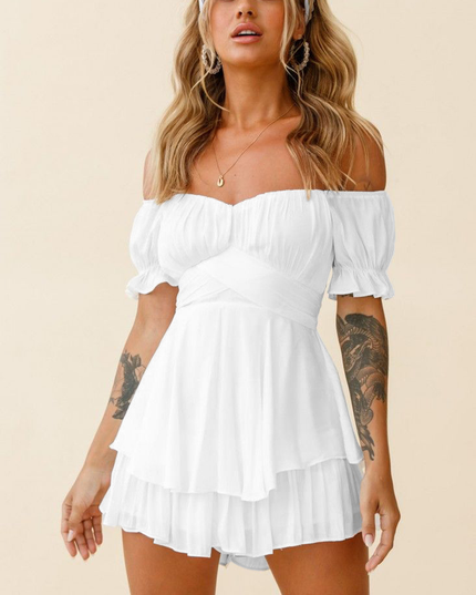 Front view of a white off-shoulder tiered ruffle romper, with a sweetheart neckline, short puffed sleeves, and a crossover waist.