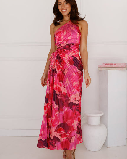 Women's elegant one shoulder maxi dress in a fuchsia and crimson floral print, featuring a pleated skirt and waist cutout detail.