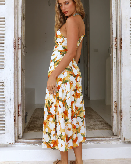 Side view of women's floral one-shoulder midi dress, white with orange flowers, showing mermaid hem.