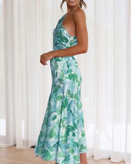 Side profile of women's floral one shoulder ruched bust midi dress in green and light blue.