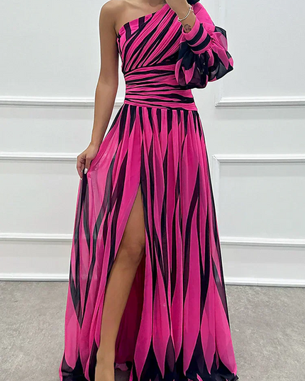 Pink and black striped one-shoulder maxi dress with a single long sleeve and thigh-high slit detail