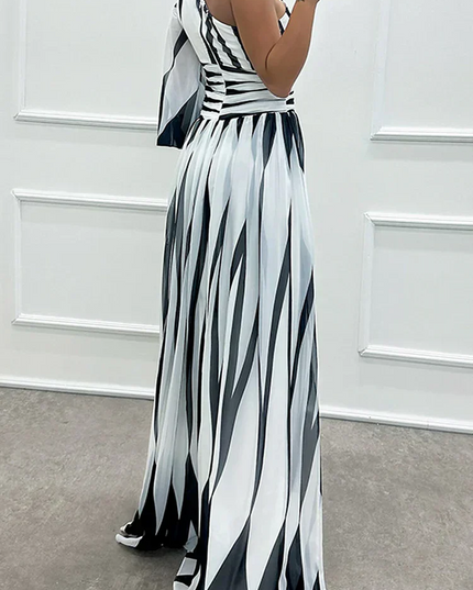 Side view of black and white striped one-shoulder maxi dress, showing the flowing skirt and single sleeve