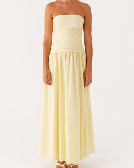 Front view of a light yellow strapless ruched maxi dress with a gathered drop waist.