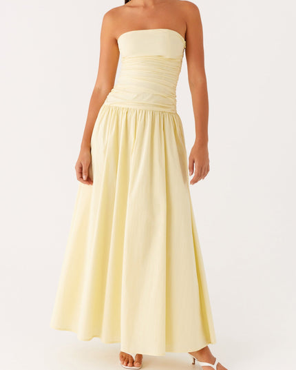 Full body view of the women's strapless ruched drop waist maxi dress in a soft yellow hue.