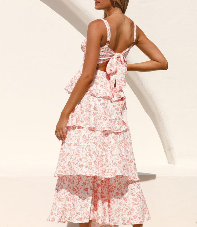 Back view of a woman wearing the pink floral ruffled maxi dress, showcasing the tie-back detail and tiered skirt.