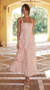 Front view of a women's pink floral ruffled maxi dress with spaghetti straps, for a wedding guest.