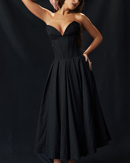 Full length view of black strapless boned bodice midi dress with pleated skirt, woman posing.