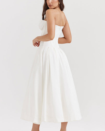 Three-quarter back view of a white strapless midi dress, showcasing the pleated skirt and corset-style top.