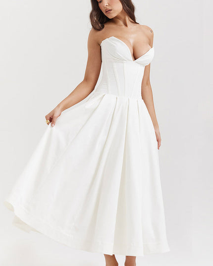 Side view of a white strapless boned bodice midi dress, showing the full pleated skirt and white heels.