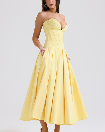 Angled view of a women's light yellow strapless boned bodice pleated midi dress, with pockets