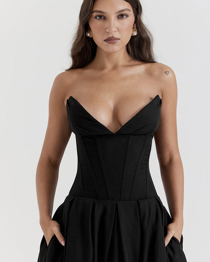 Close up of black strapless boned bodice midi dress, sweetheart neckline and pleated skirt with pockets.