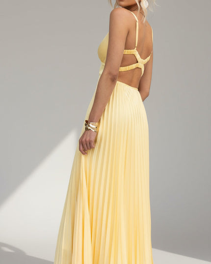Three-quarter back view of the yellow pleated maxi dress, showing the criss-cross back straps and cut-outs.