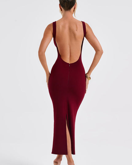 Back view of a women's burgundy midi dress showcasing the low back design and a discreet slit, worn with nude heels.