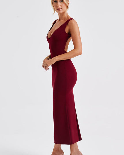 Side view of a women's burgundy midi dress, showing the deep V-neckline and low-cut back, with a side slit.