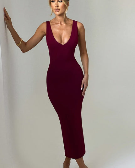 Front view of a women's burgundy plunge neck midi dress, sleeveless with a fitted silhouette, paired with clear heels.