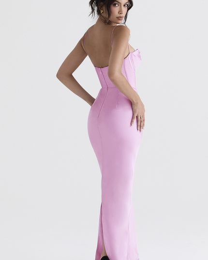 Back view of a women's pink satin corset plunge neck maxi dress, the sleek fit and a back slit, with black high heels.