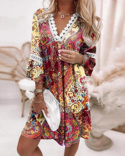 Women's summer mini dress in a vibrant red, yellow, and orange paisley print with white lace V-neck.