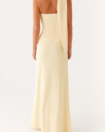 Back view of a women's pale yellow strapless maxi dress, showing the draped scarf detail from behind.