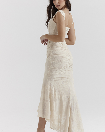 Three-quarter view of a cream floral ruched maxi dress, highlighting the fitted bodice and flowing skirt.