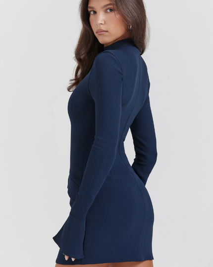 Side profile of a navy blue mock neck mini dress, showcasing the fitted silhouette and long sleeves with ruffle cuffs.