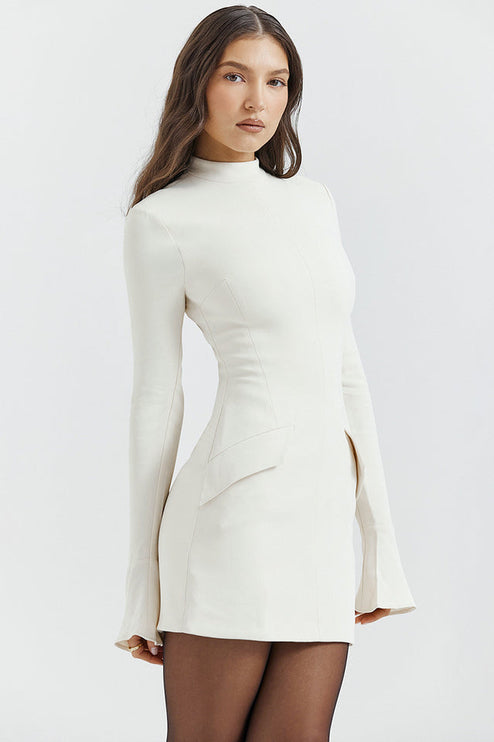 Side view of a cream mock neck long sleeve mini dress with ruffle cuffs, highlighting the fitted bodice and skirt.