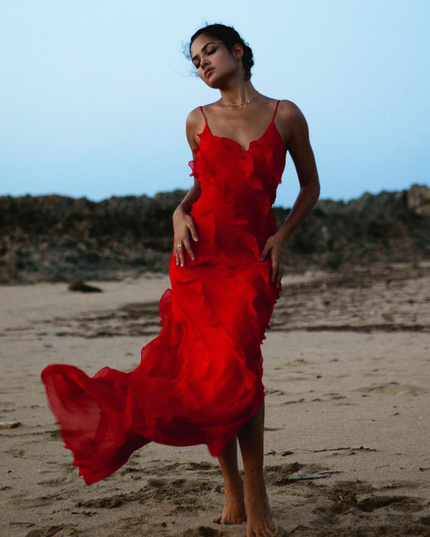 Red V-neck ruffle side slit maxi dress flowing on a beach, showcasing the airy fabric.