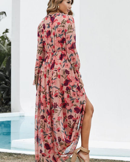 Back view of a women's pink floral long sleeve maxi dress with a ruffled V-neck and tiered skirt.