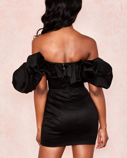 Back view of the black off-shoulder ruffle satin mini dress, showing the zipper detail and fitted skirt.