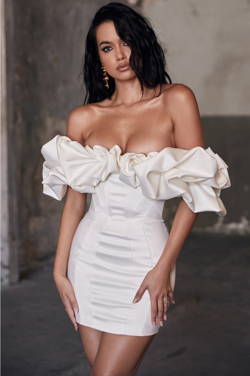 Elegant off-shoulder satin mini dress in creamy white with dramatic ruffled sleeves and a structured bodice.