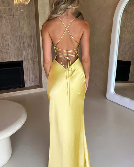Full back view of the yellow satin maxi dress, displaying the flowing skirt and delicate tie-back closure.