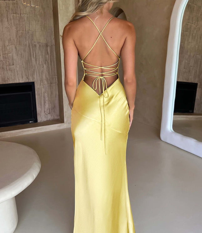 Full back view of the yellow satin maxi dress, displaying the flowing skirt and delicate tie-back closure.