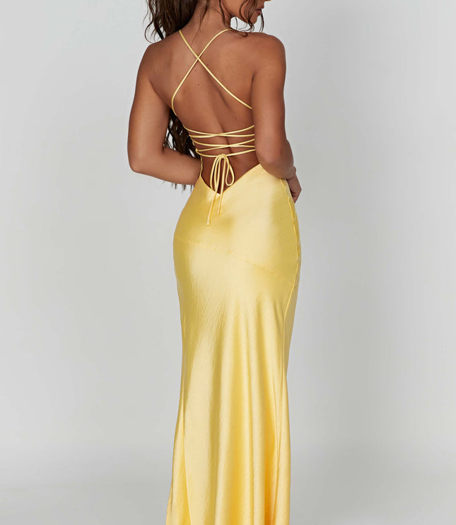 Back view of the yellow satin maxi dress, highlighting the tie-back detail and the smooth, flowing fabric.
