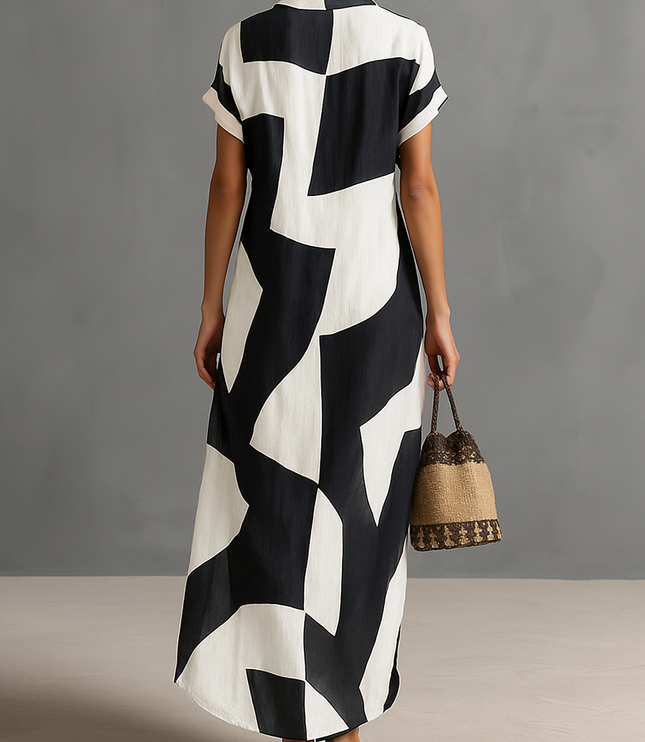 Back view of a women's black and white geometric print maxi dress with short sleeves, showcasing the full length and pattern.
