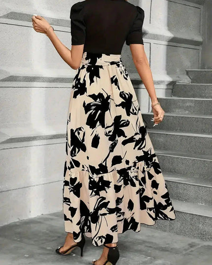 Back view of a women's high waist maxi dress with a black floral print on beige, showing the tiered skirt and short black sleeves.
