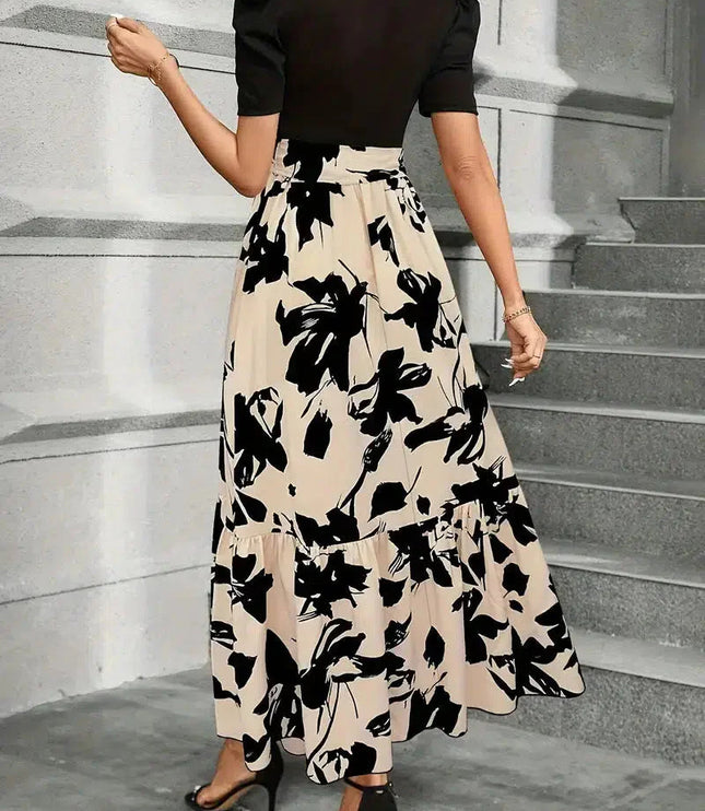 Back view of a women's high waist maxi dress with a black floral print on beige, showing the tiered skirt and short black sleeves.