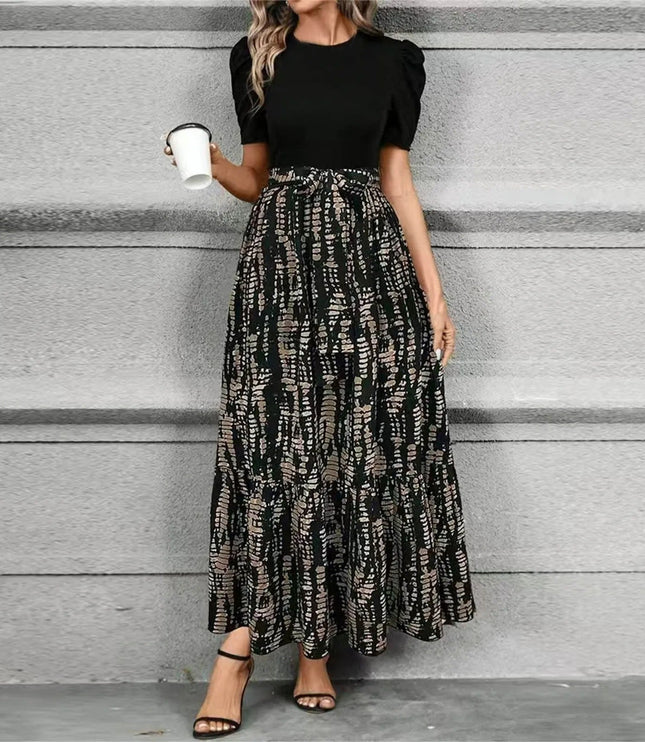 Women's black short sleeve top paired with a high waist maxi dress featuring a dark abstract geometric print in earthy tones.