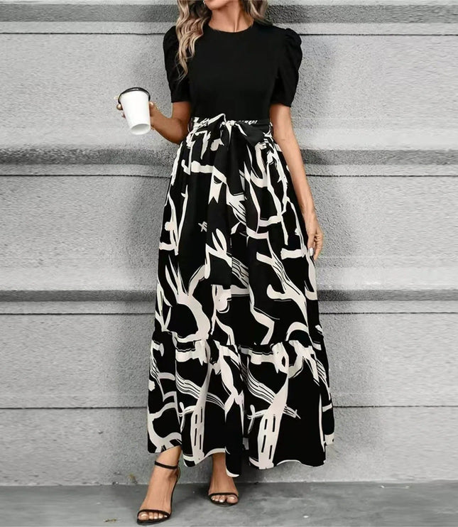 Women's black short sleeve top with a high waist maxi dress featuring a bold black and white abstract pattern, tied at the waist.