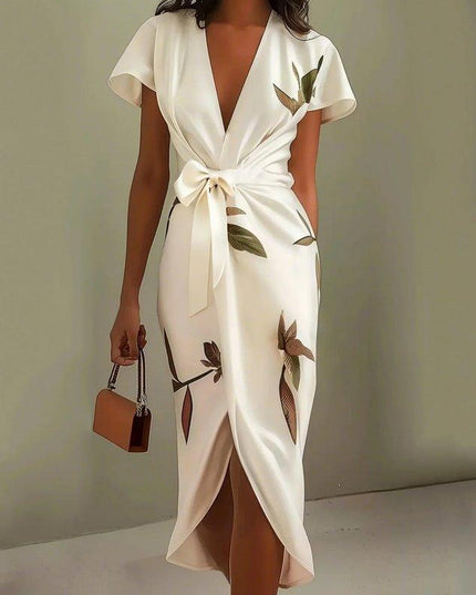 Full-length view of a women's white leaf print v-neck short sleeve midi wrap dress, featuring a front tie.