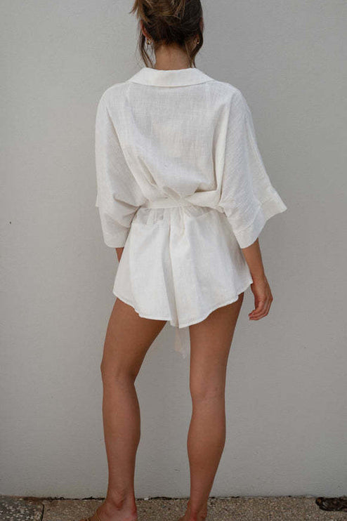 Full back view of a women's white summer collared short romper, showcasing the fabric texture and tied waist.
