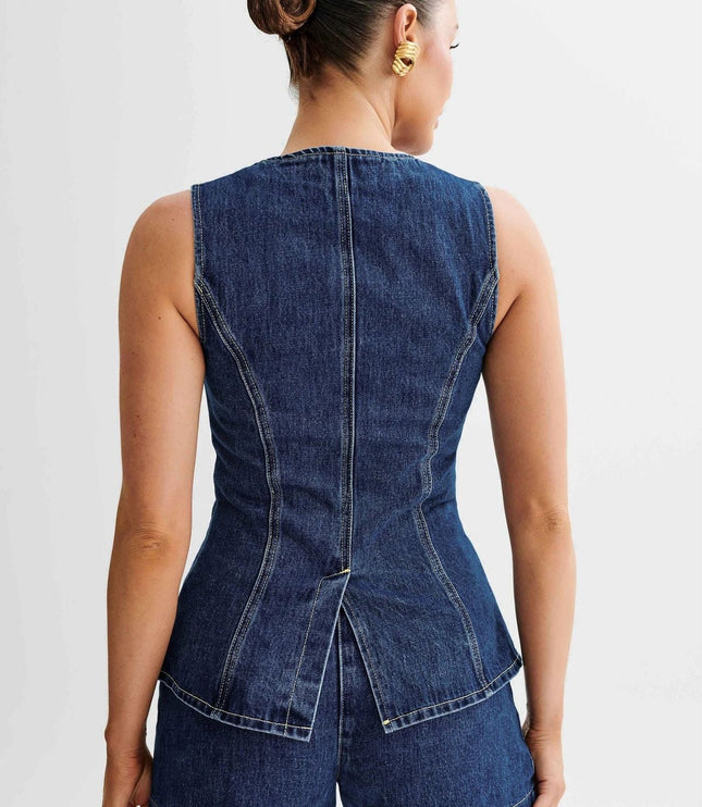 Back view of a sleeveless dark wash denim top with a peplum hem, showing seam details and matching denim shorts.