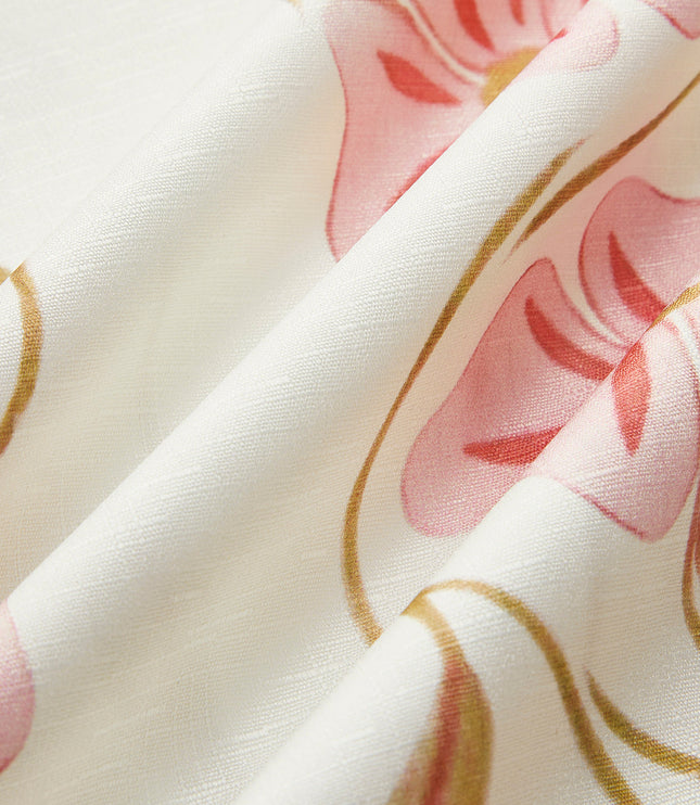 Close-up of the fabric texture of the white summer floral mini dress with pink and gold flower pattern.