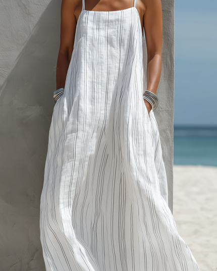Detail of the white striped maxi dress, highlighting the vertical black stripes and the functional side pockets.