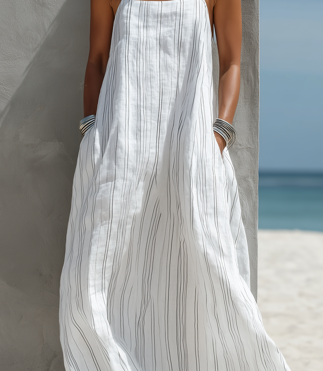 Detail of the white striped maxi dress, highlighting the vertical black stripes and the functional side pockets.