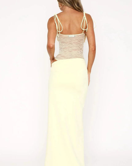 Back view of a pale yellow women's lace panel maxi dress with spaghetti straps and a square neckline, showing the full length.