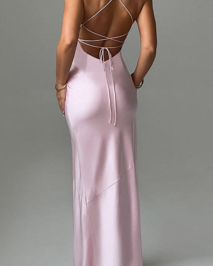 Back view of a light pink formal maxi dress featuring criss-cross spaghetti straps and a tie-back detail.