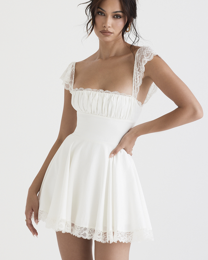 Front view of a white women's mini dress with lace cap sleeves and a square neck, featuring a ruched bust and lace trim on the hem.