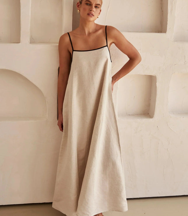 Side view of a light beige women's summer maxi dress with a relaxed fit and black trim.
